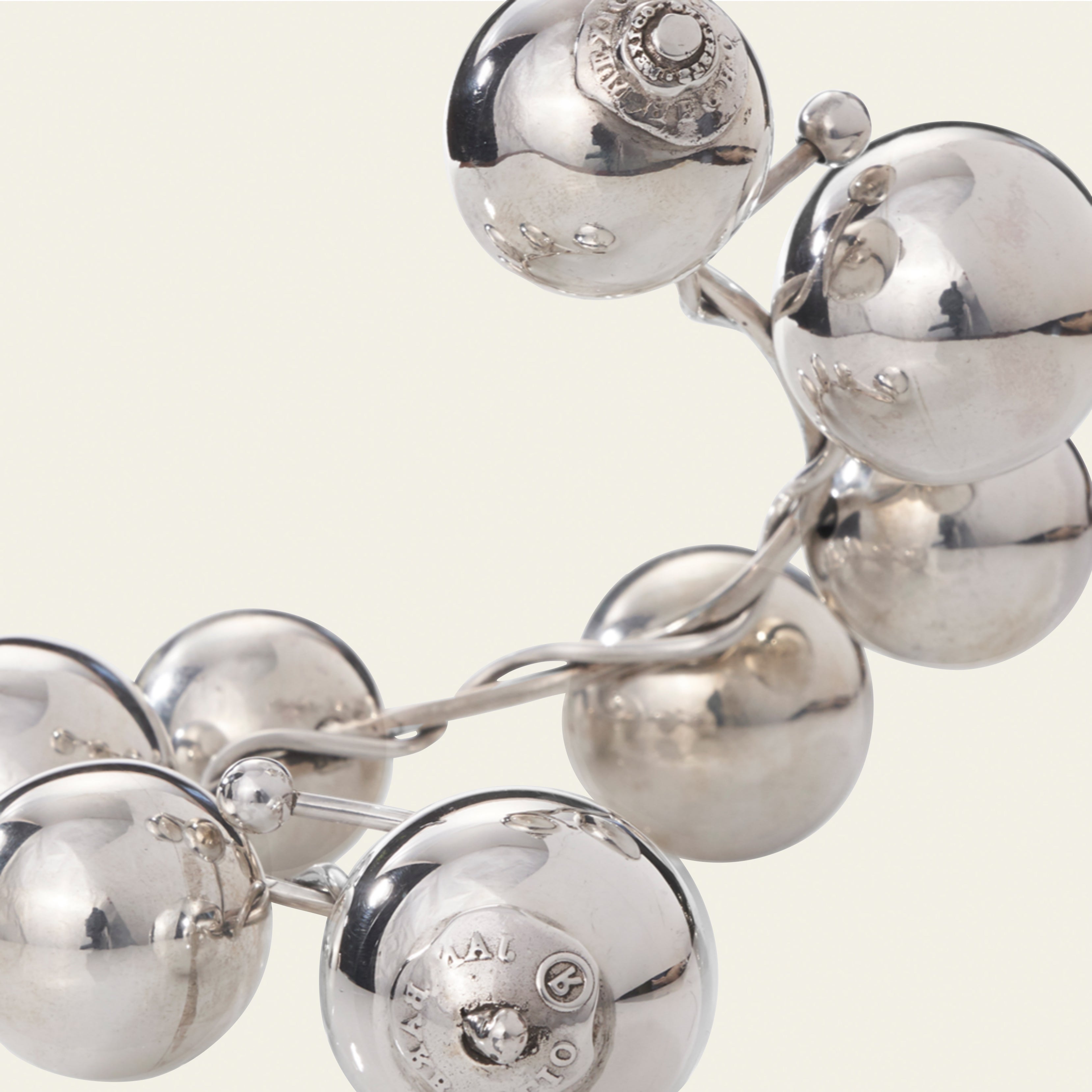 Big silver beads with engraved signature seals. Simple background.