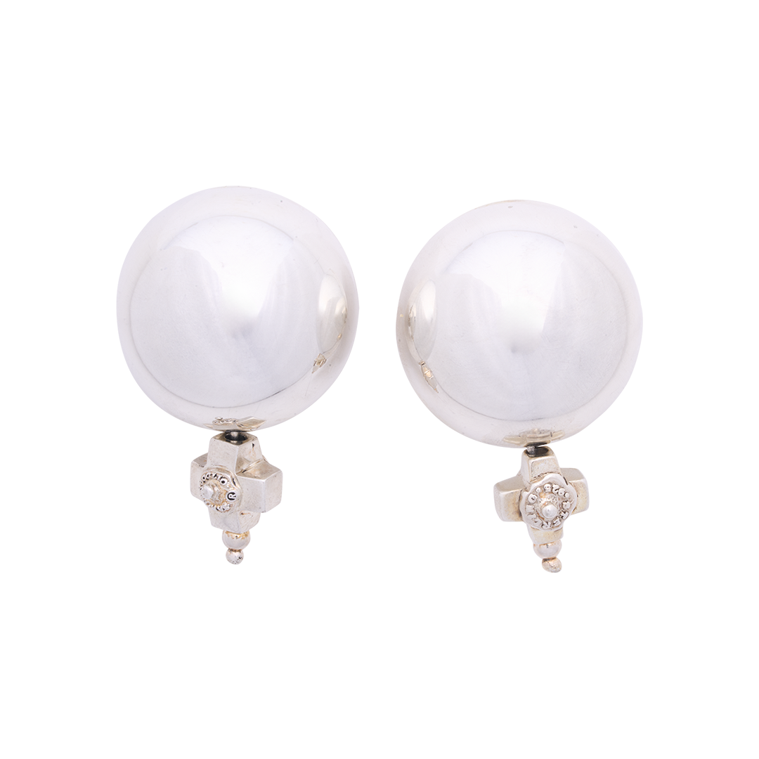 Two silver circle earrings with a silver cross under each sphere.