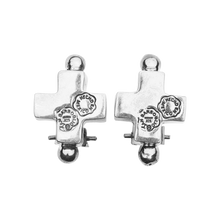 Two silver cross earrings with a silver stud on the top and on the bottom. Each one with two seals engraved. Plain background.