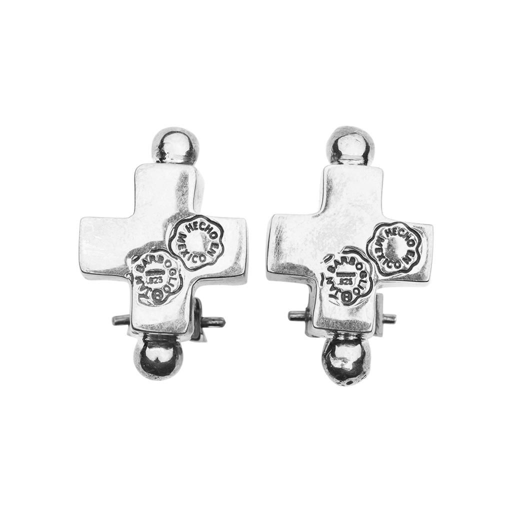 Two silver cross earrings with a silver stud on the top and on the bottom. Each one with two seals engraved. Plain background.