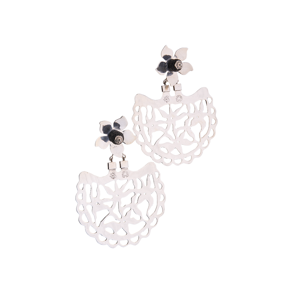 Two silver earrings with a flower at the top. The flower has a volcanic black stone in the center. Below the flower is an open  fan shaped piece with an intricate design.