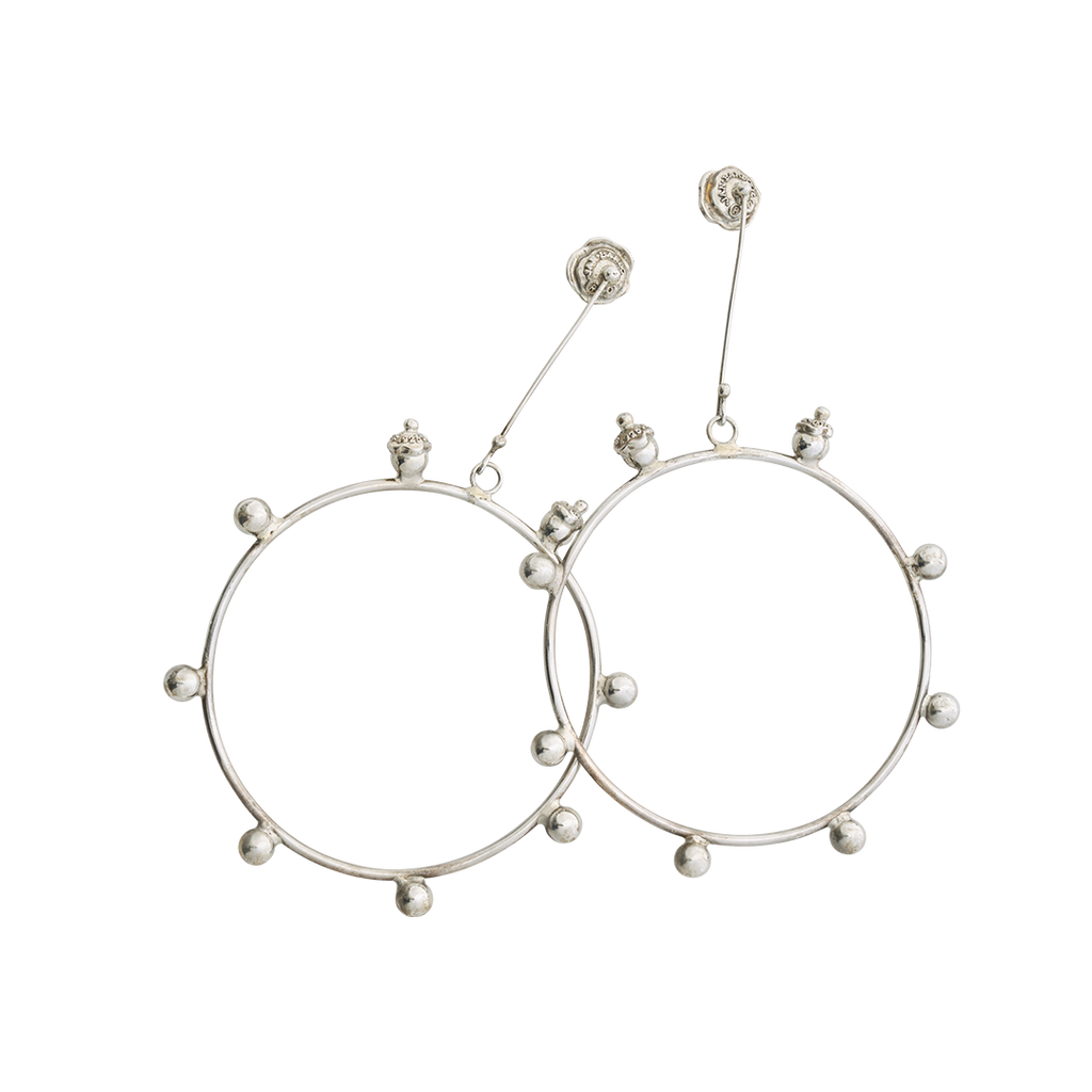 Silver hoops with decorative balls with seals around the hoop. Holding the hoop is a silver stick with the designer's seal.