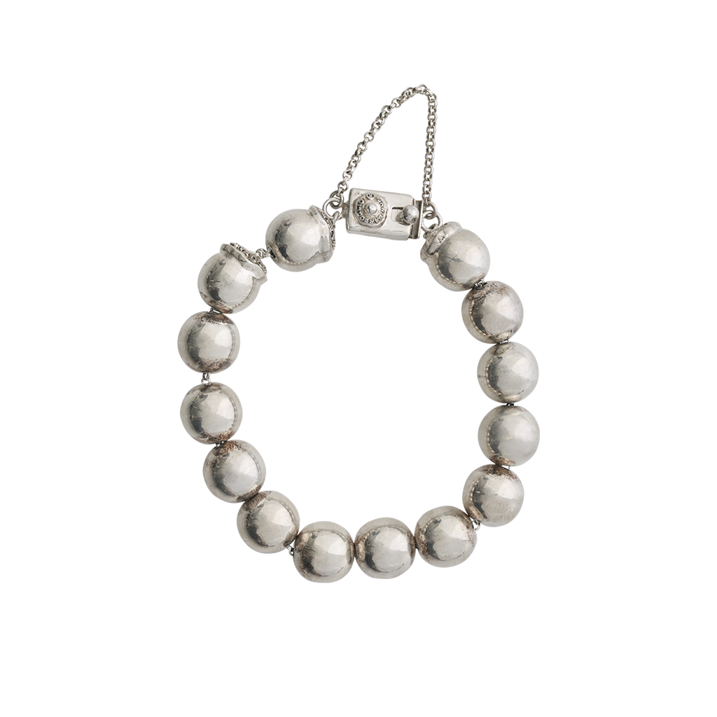 A silver bead bracelet with a delicate chain and a rectangle closing mechanism with a seal stud.