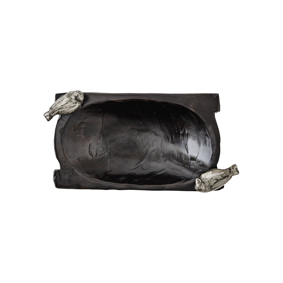 A hand carved small rectangular primitive wood bowl with two cast iron birds. Top view.