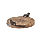 A  round wood  cutting board with cast iron bird handles.