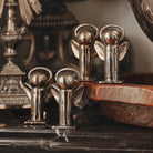 Four  mini angels plated in nickel with halo on a square base. On top of a table and a wooden tray.