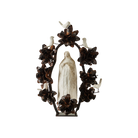 A hand carved stone statue representing the spirit of the virgin of  Guadalupe surrounded by an aura and halo of iron flowers and stone birds. 
