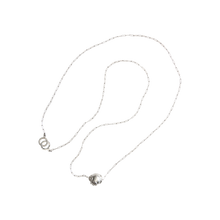 a delicate silver chain necklace with a silver bead in the center.