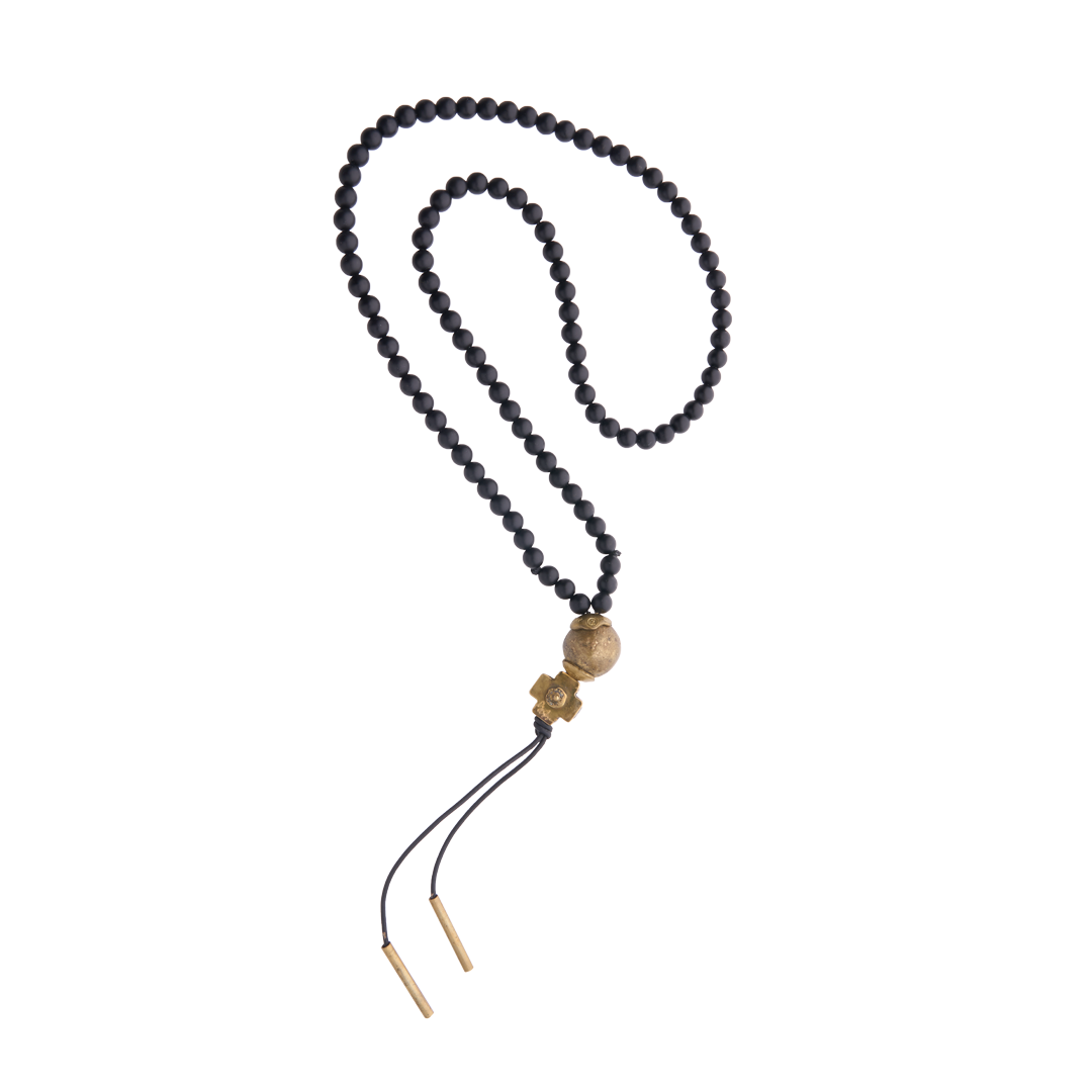 A black beads necklace with a bronze ball and cross and at the end black leather strings with bronze cylinders.
