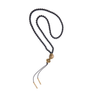 A black beads necklace with a bronze ball and cross and at the end black leather strings with bronze cylinders.