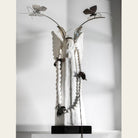 A white stone angel with nickel butterfly crown and white blessing beads with flowers. White bacckground.