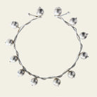 A silver necklace with silver studs surrounding it.