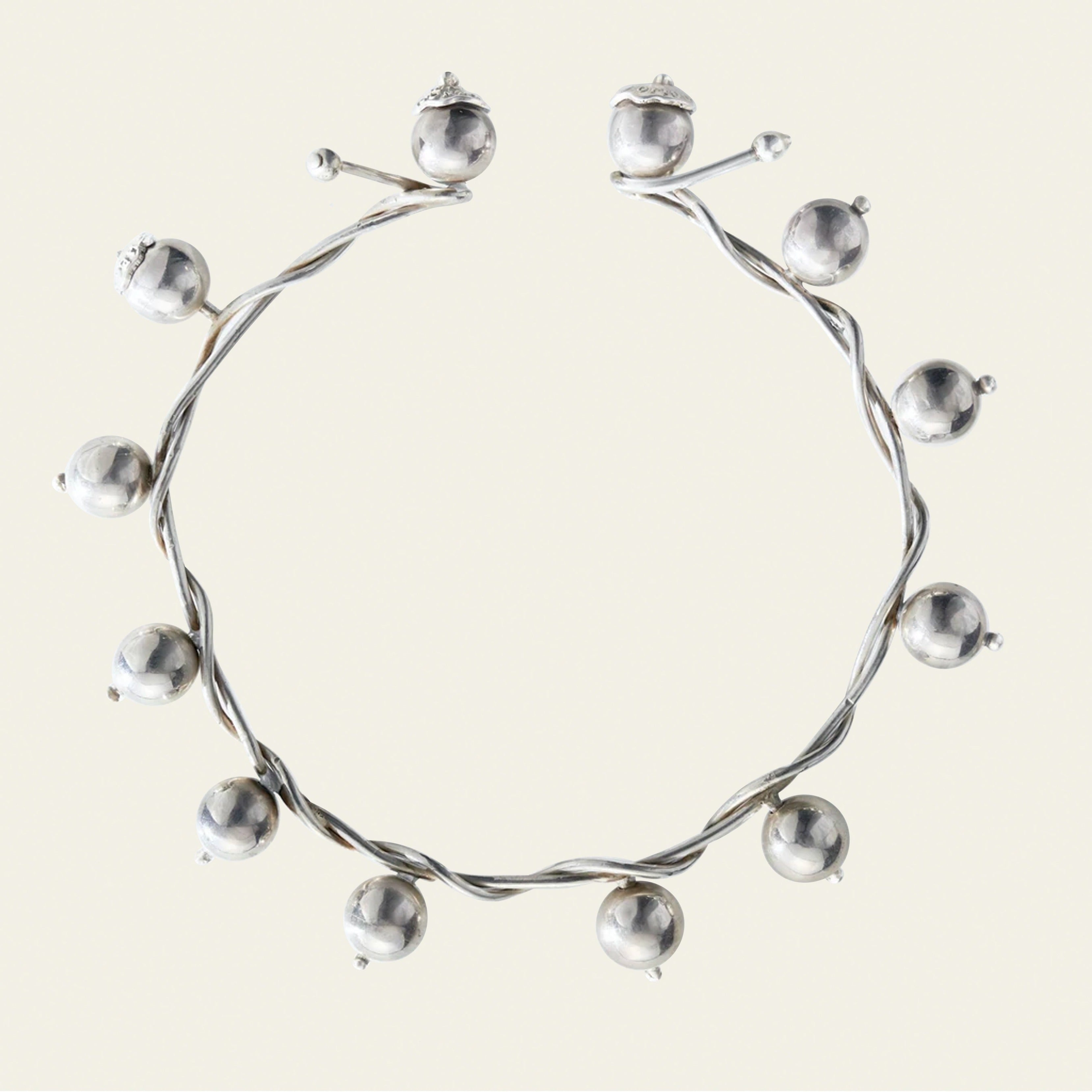 A silver necklace with silver studs surrounding it.