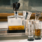 Clear glass decanter with dual purpose cork & screw, eagle topper and iron stand. Some glasses and a tray. 