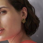 woman using golden earring with a cross shape