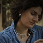 A woman in a denim shirt wearing silver jewelry.